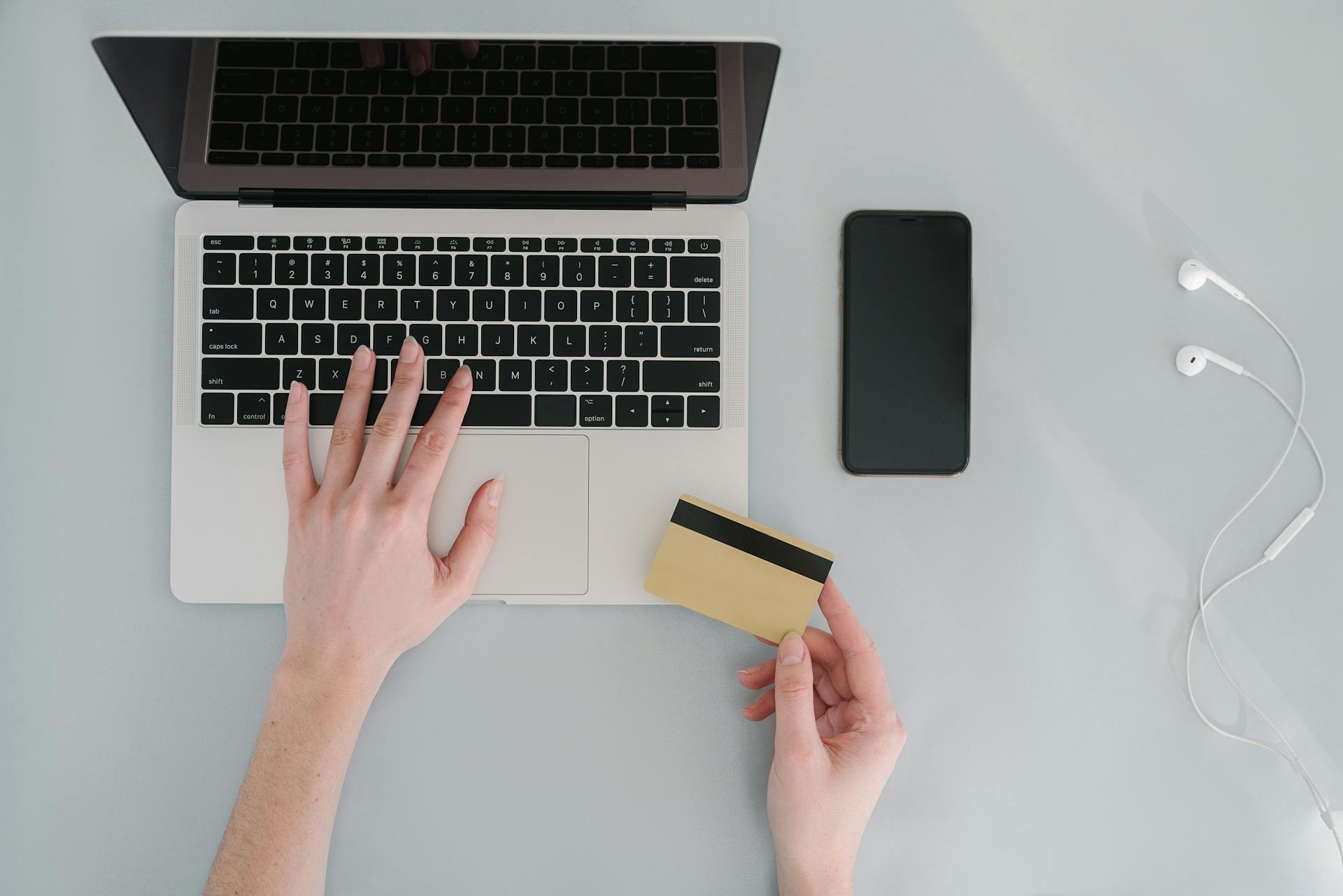 A Person Transacting a Bank card Online Using a Laptop