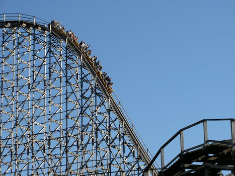 Experience the exhilarating thrill of a roller coaster ascending the steep peak at an amusement park.