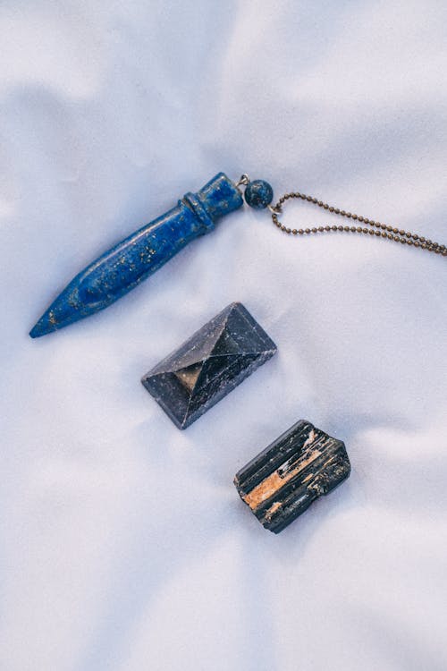 Blue and Black Gemstones on White Surface
