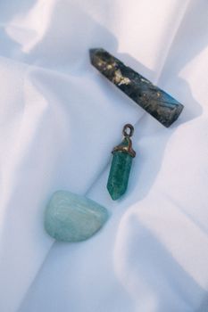 Close-up of diverse healing crystals displayed on soft white fabric, capturing natural beauty.