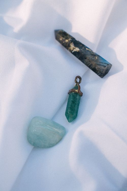 Free Close-up of diverse healing crystals displayed on soft white fabric, capturing natural beauty. Stock Photo