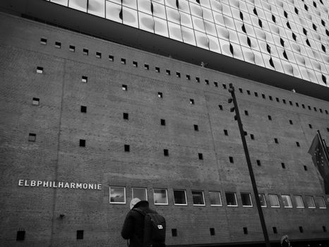 Man in front of a Modern Philharmonic Building