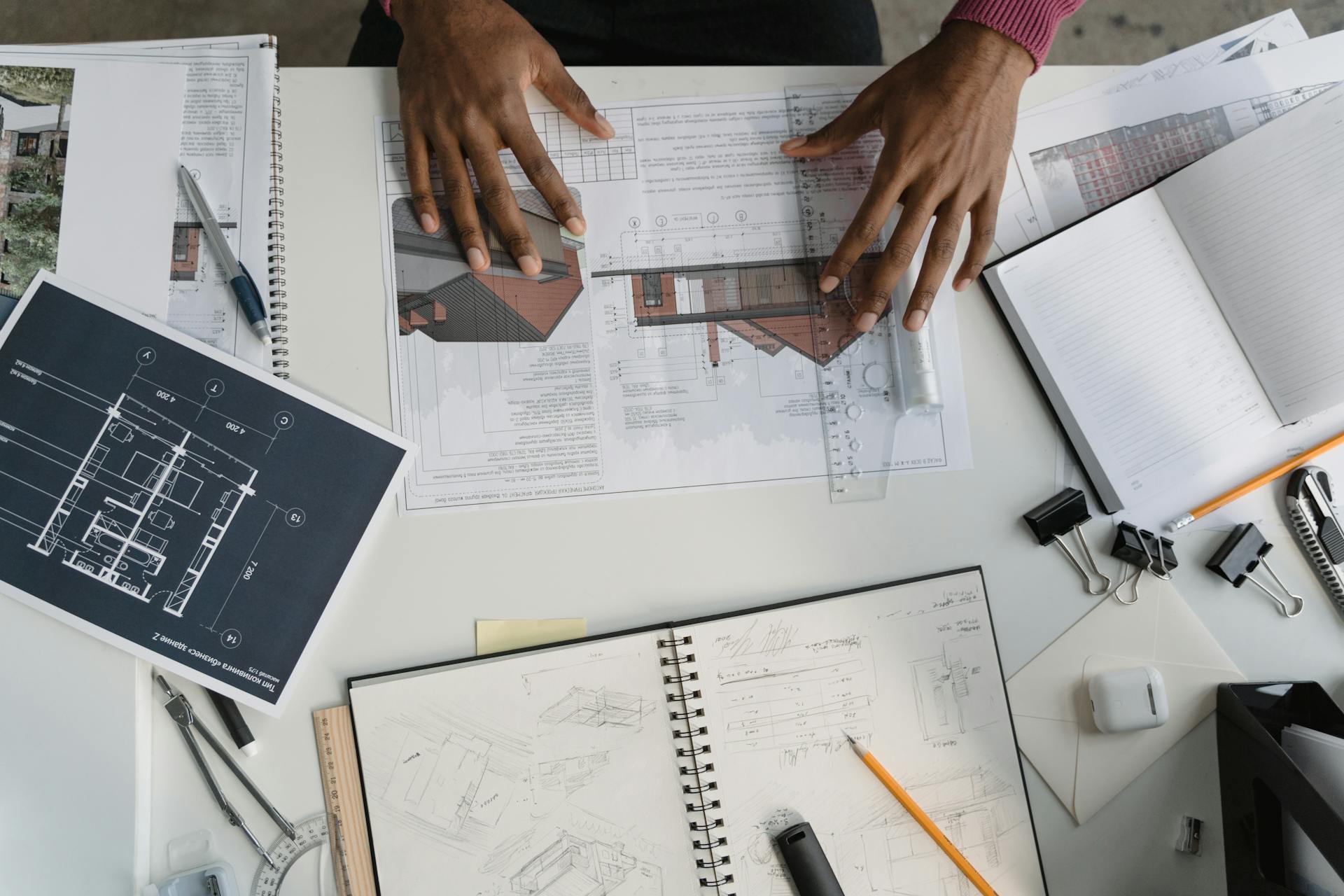 Architect analyzing blueprints and sketches at a modern workspace.