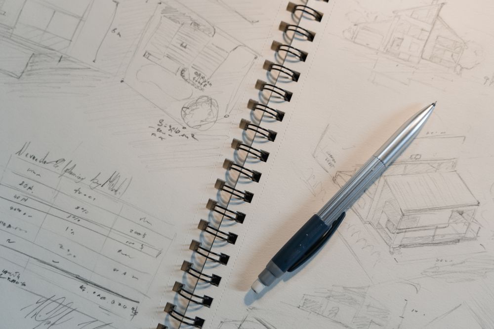 A spiral-bound sketchbook of plant drawings with a pencil