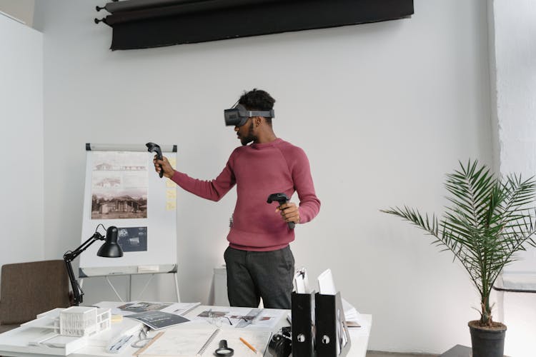 Man In Pink Long Sleeve Shirt Wearing Vr Headset With Controllers