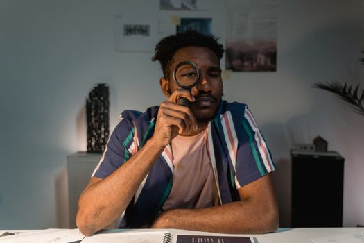 A Man Holing Black Magnifying Glass while Looking at the Camera