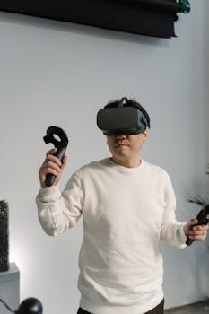 Adult male immersed in virtual reality gaming with headset and controllers, enjoying digital interaction.