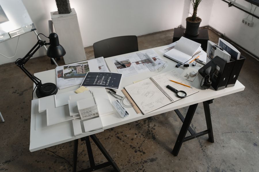 Mesa de trabalho do atelier LUMEN com maquetes e desenhos técnicos