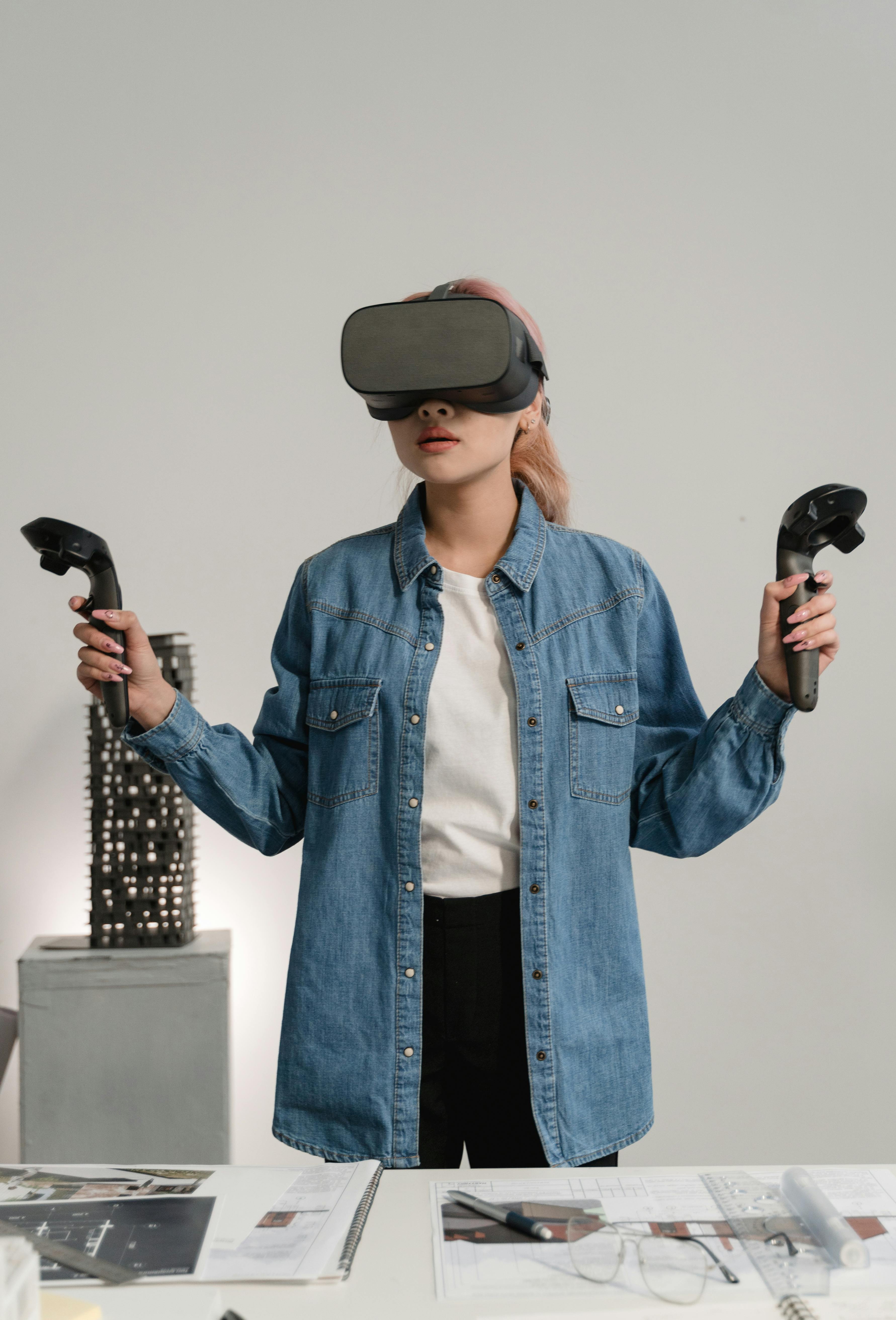 woman in denim shirt using an oculus virtual reality headset with controllers