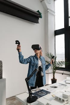 A woman experiences virtual reality gaming with VR headset and controllers in a modern indoor setting.