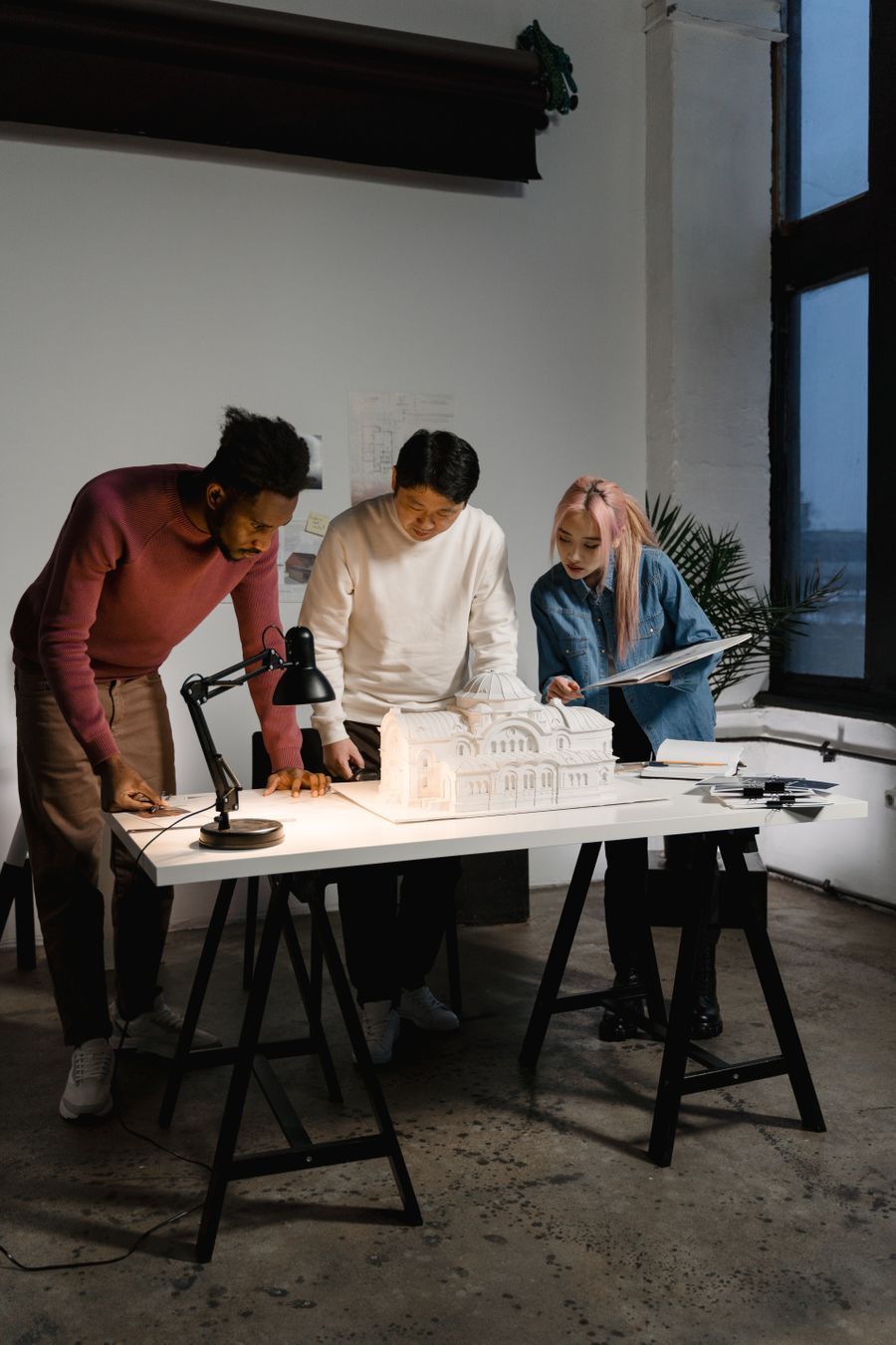 Equipa da LUMEN Arquitetura a analisar uma maquete no atelier