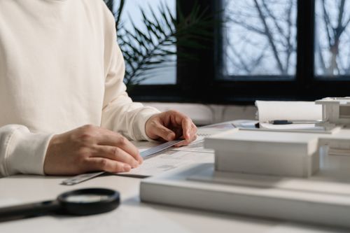Free Architect focusing on drafting plans with precise measurements indoors. Stock Photo