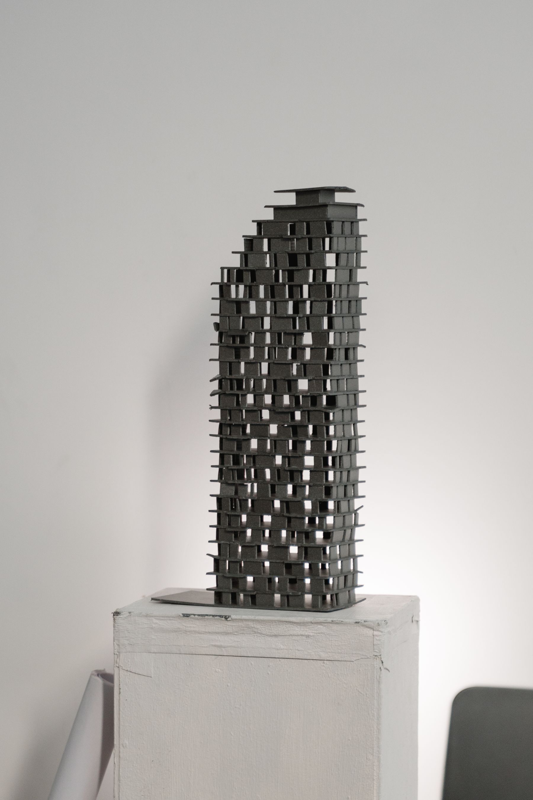 Hands building a physical architectural model on a studio table