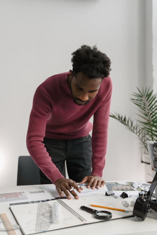 A  Man in Pink Sweater Working Inside an Office