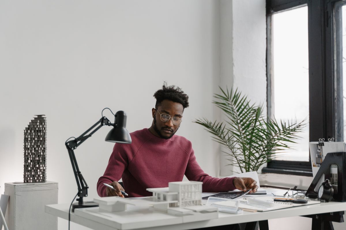 A designer working at a desk by a window — photo by Tima Miroshnichenko on Pexels