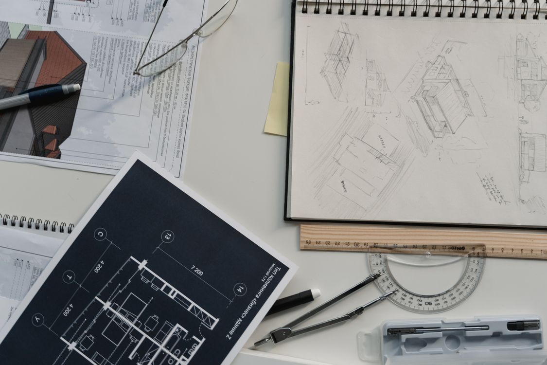 Architect reviewing construction blueprints and plans at a desk with digital tools
