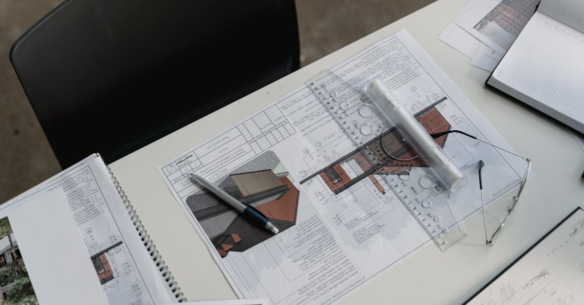 Top view of architectural blueprints and drafting tools on a workspace desk.