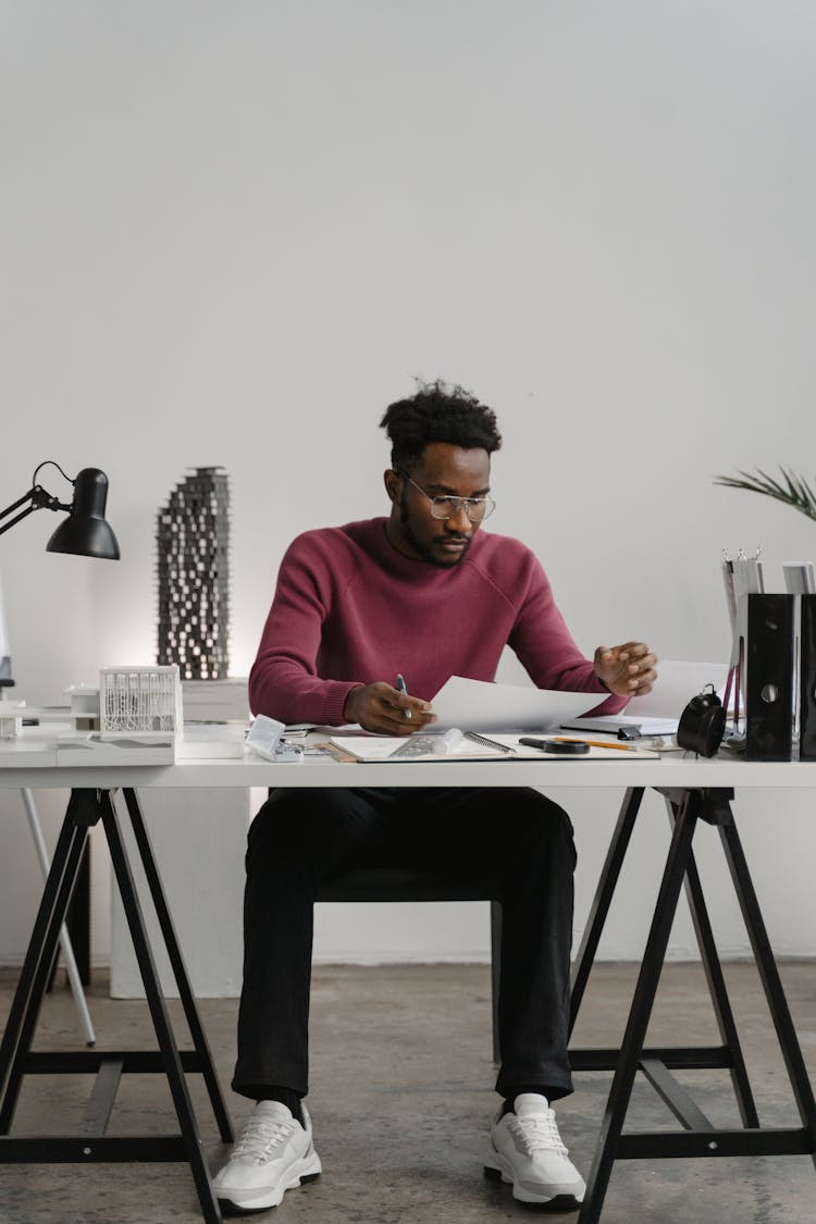 A Man Reviewing Documents In His Office