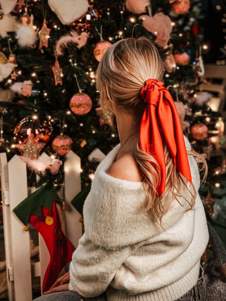 A Woman In White Sweater With Red Ribbon On Hair