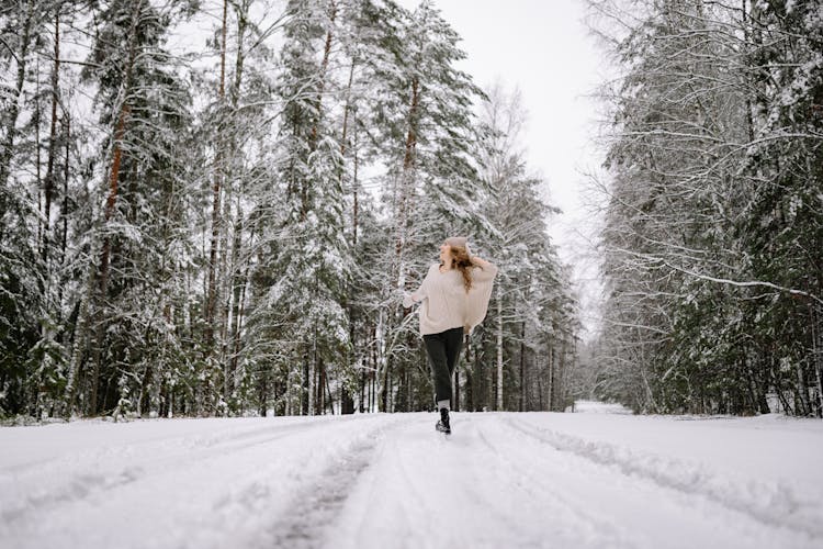 Woman Running In Winter Forest