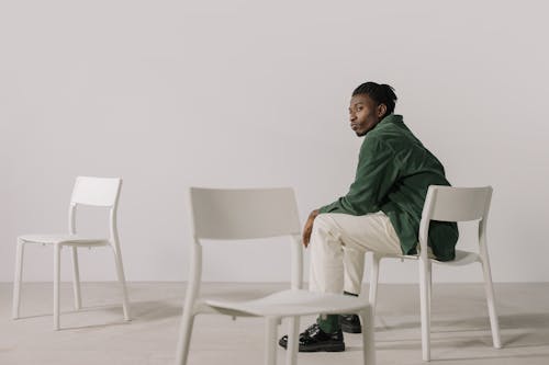 A Man in Green Long Sleeves Sitting on the Chair