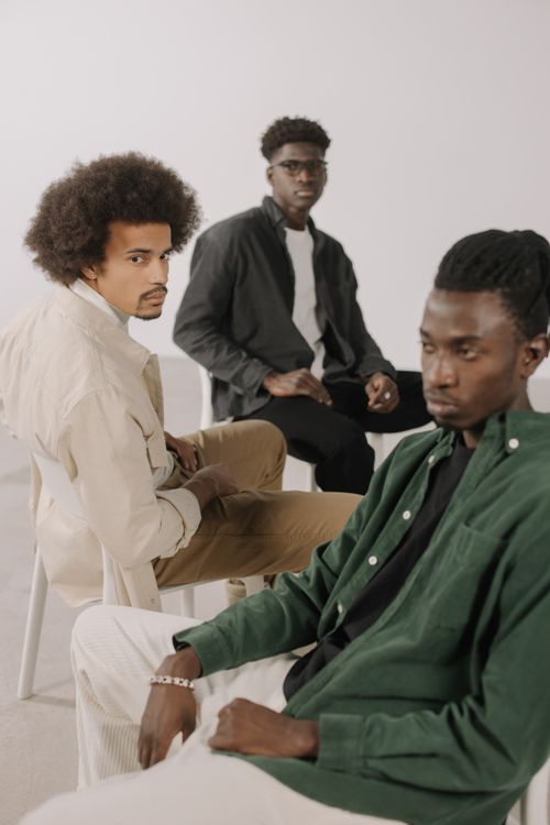Free A group of fashionable African American men posing in a studio setting, showcasing modern style. Stock Photo