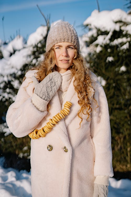 Photo of a Woman Wearing a Pink Coat and a Knit Cap
