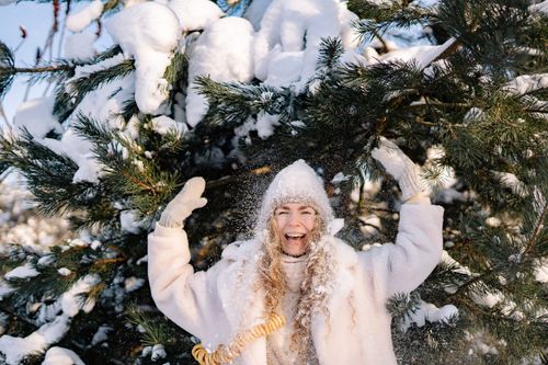 Free A cheerful woman in warm clothing enjoying a snowy winter day outdoors. Stock Photo
