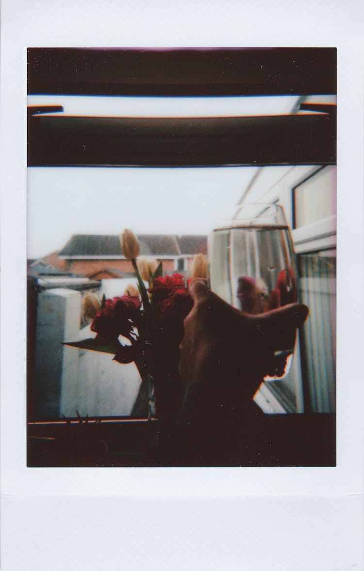 Polaroid Photo Of Hand Holding Water Glass