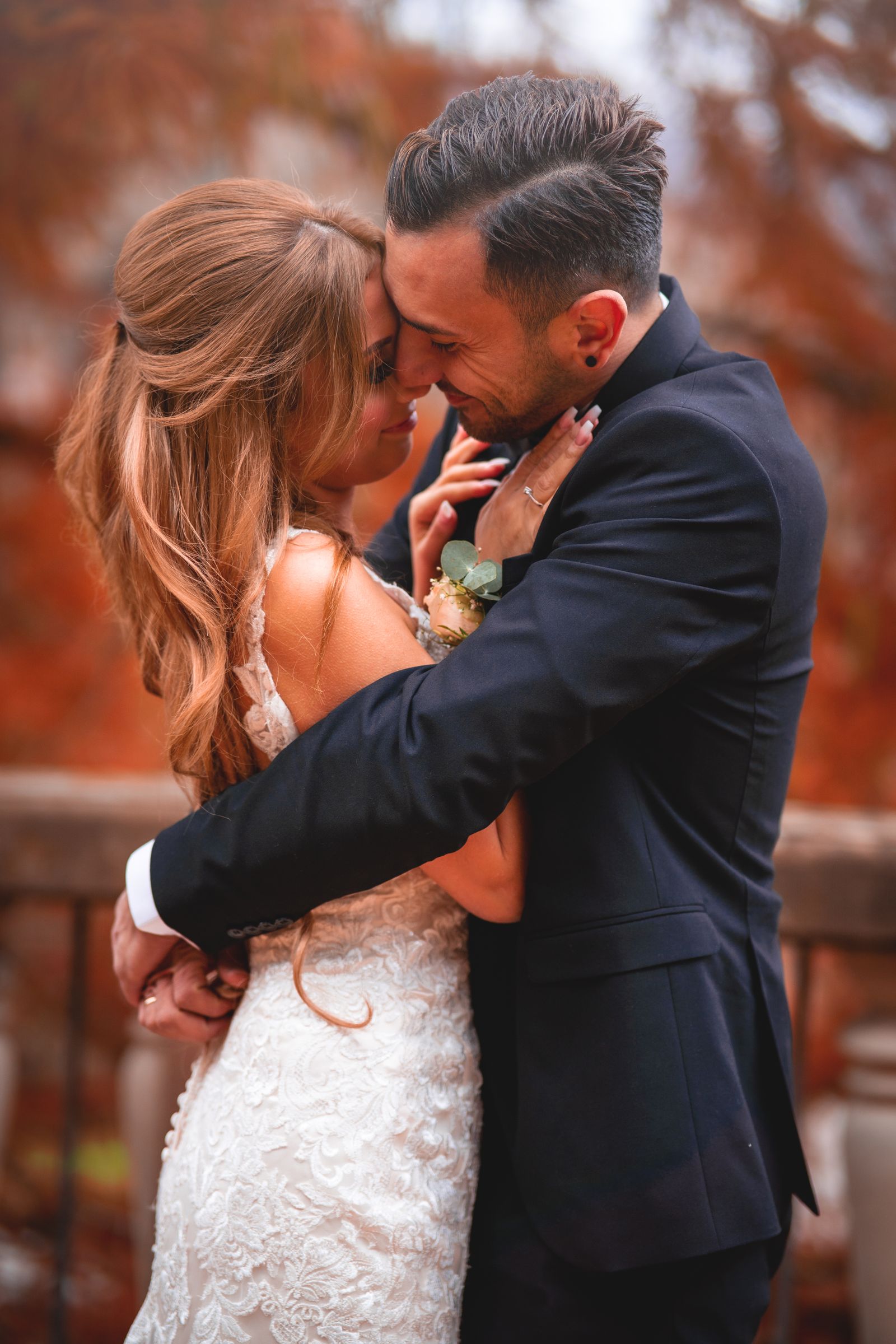 Bride and groom in a fall wedding scene with autumn foliage