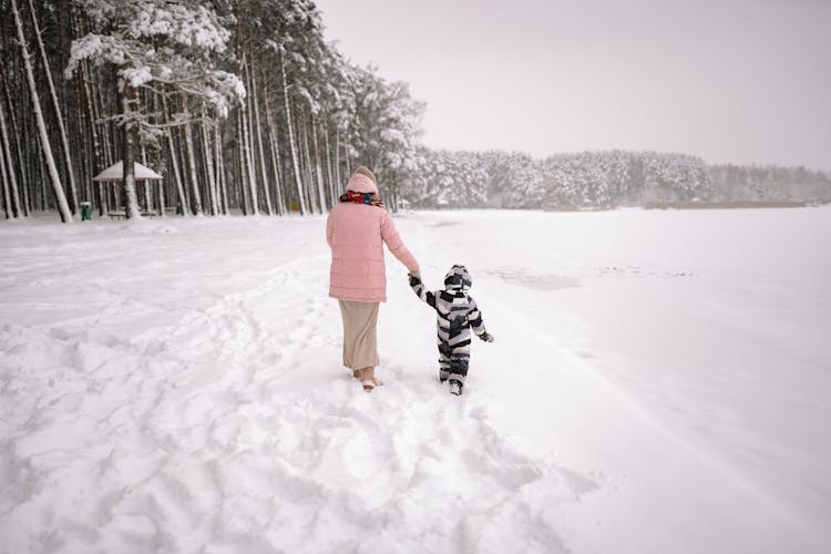 Mother And Son Walking In A Snow 