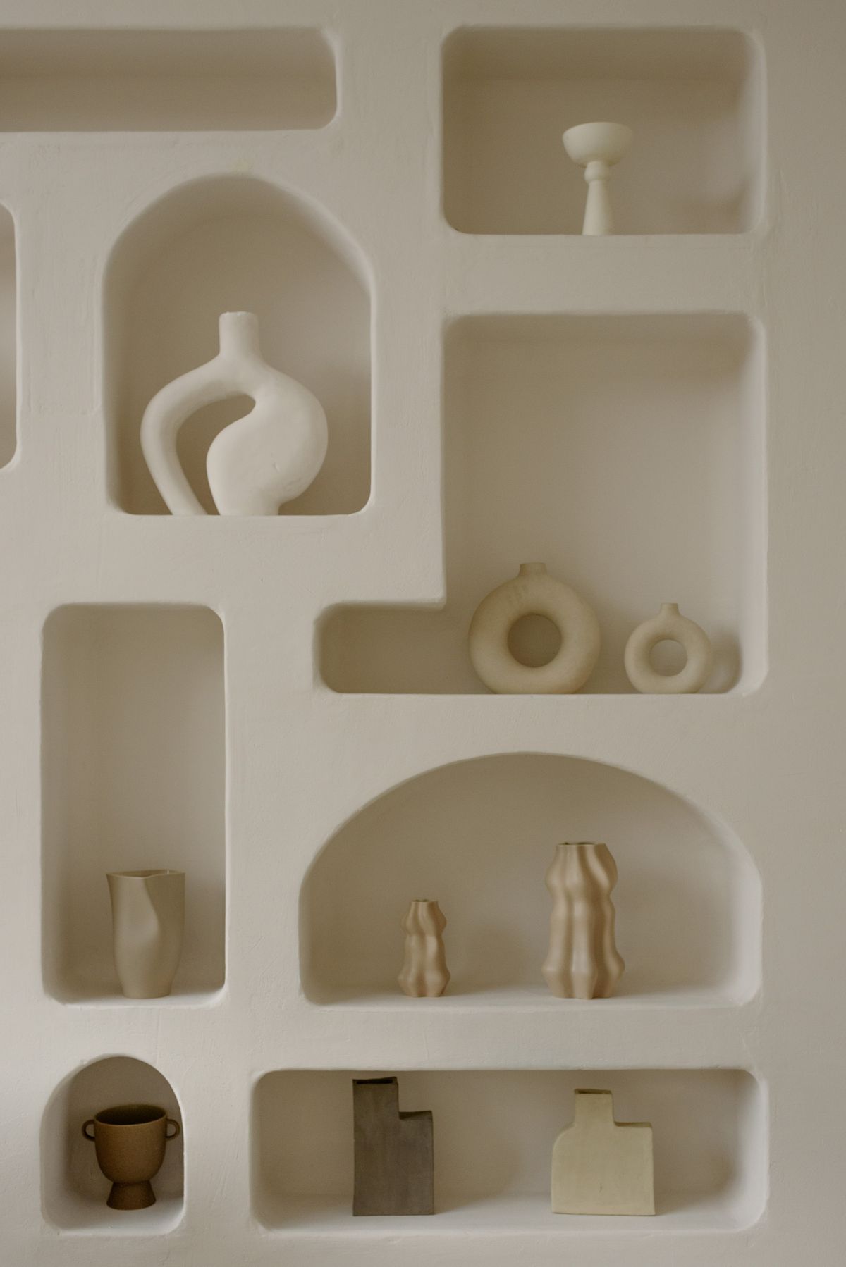 Wandplanken met keramische vazen en decoratie