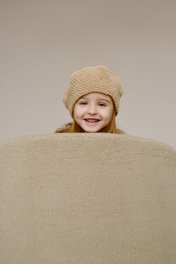 Smiling Girl In Beige Knitted Beanie