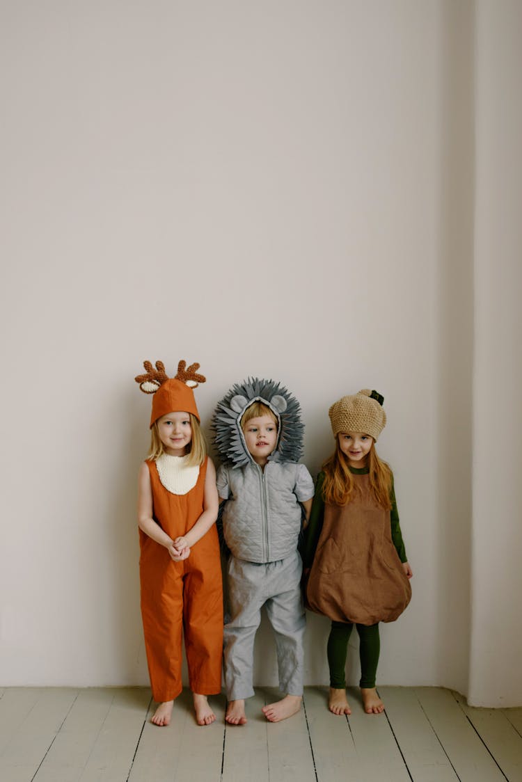 Kids Wearing Costume Standing Next To Each Other