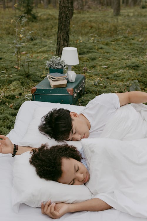 A Couple Lying on Sleeping Blanket over Grass