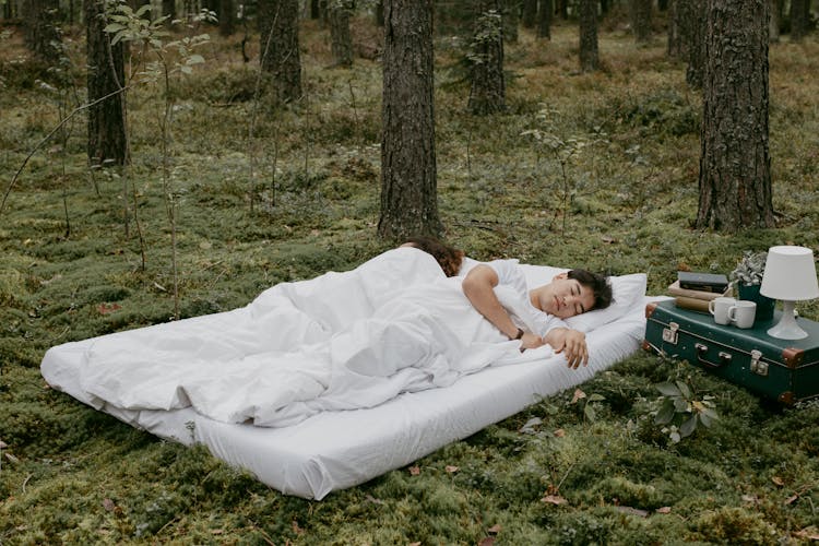 A Couple Sleeping Outdoors Over A Mattress