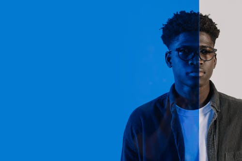 Man in Black Framed Eyeglasses Behind the Blue Transparent Glass