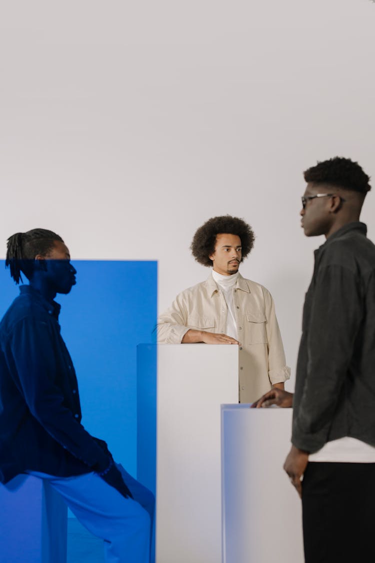 Three Young Men In Stylish Shirts Posing In A Studio