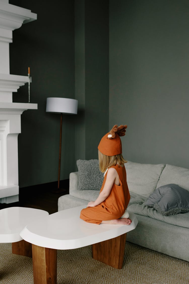 Girl In A Costume On Top Of A Coffee Table