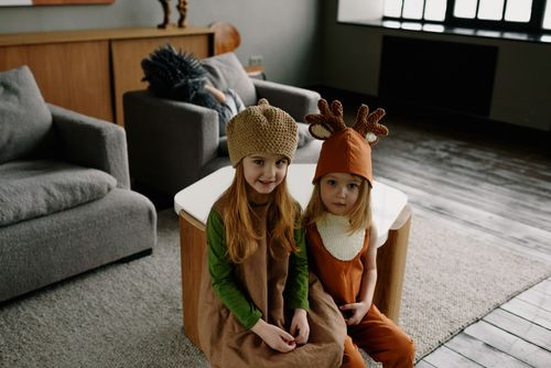 Free Two children wearing cute animal-themed costumes sitting in a cozy living room. Perfect for holidays. Stock Photo