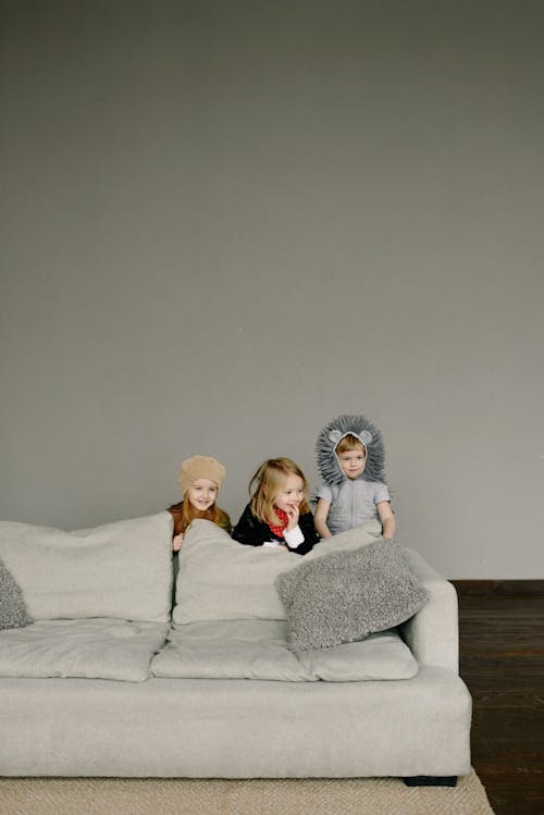 Kids in Their Costumes Standing Behind the Couch