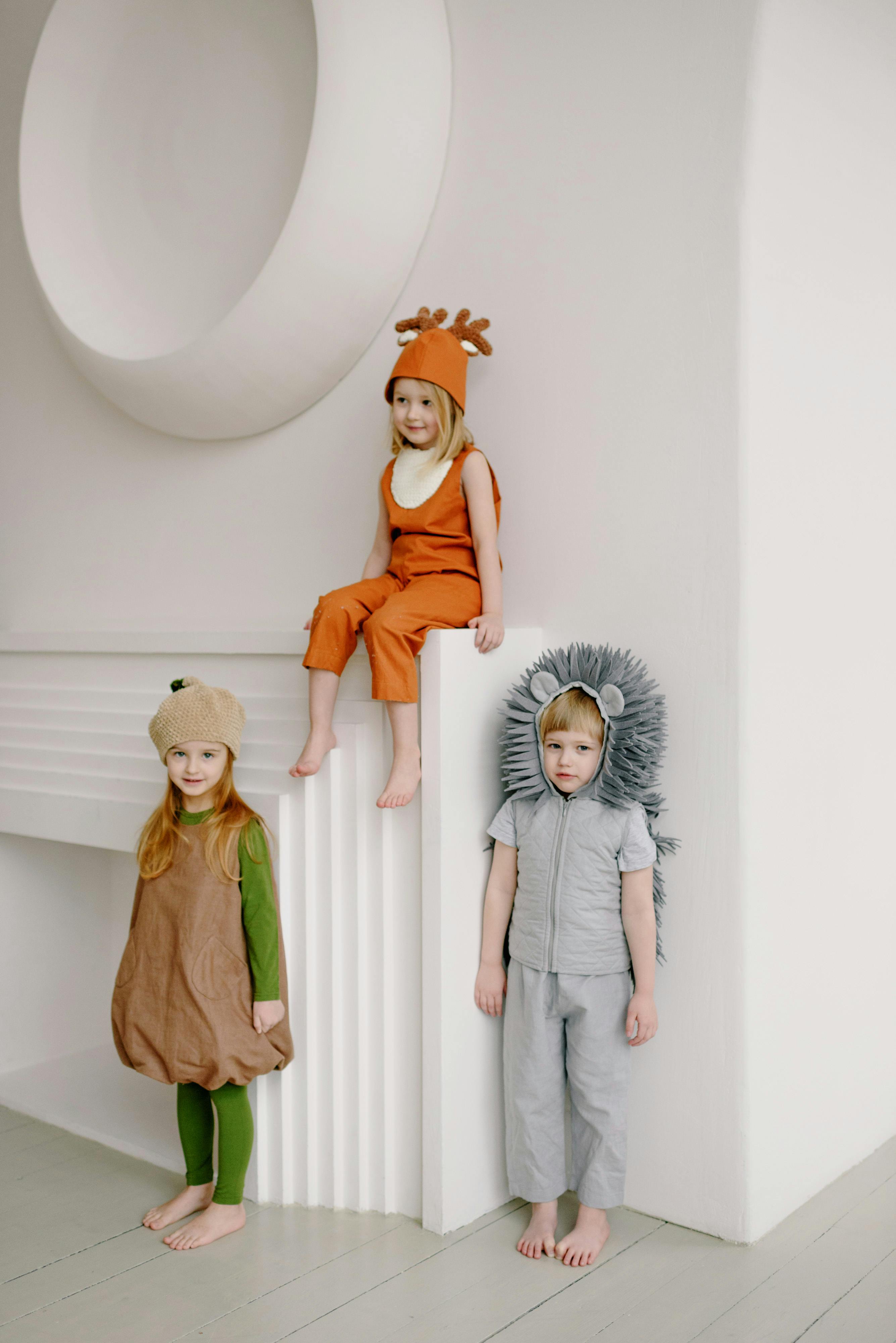 Kids Wearing Costumes Leaning on White Wall · Free Stock Photo