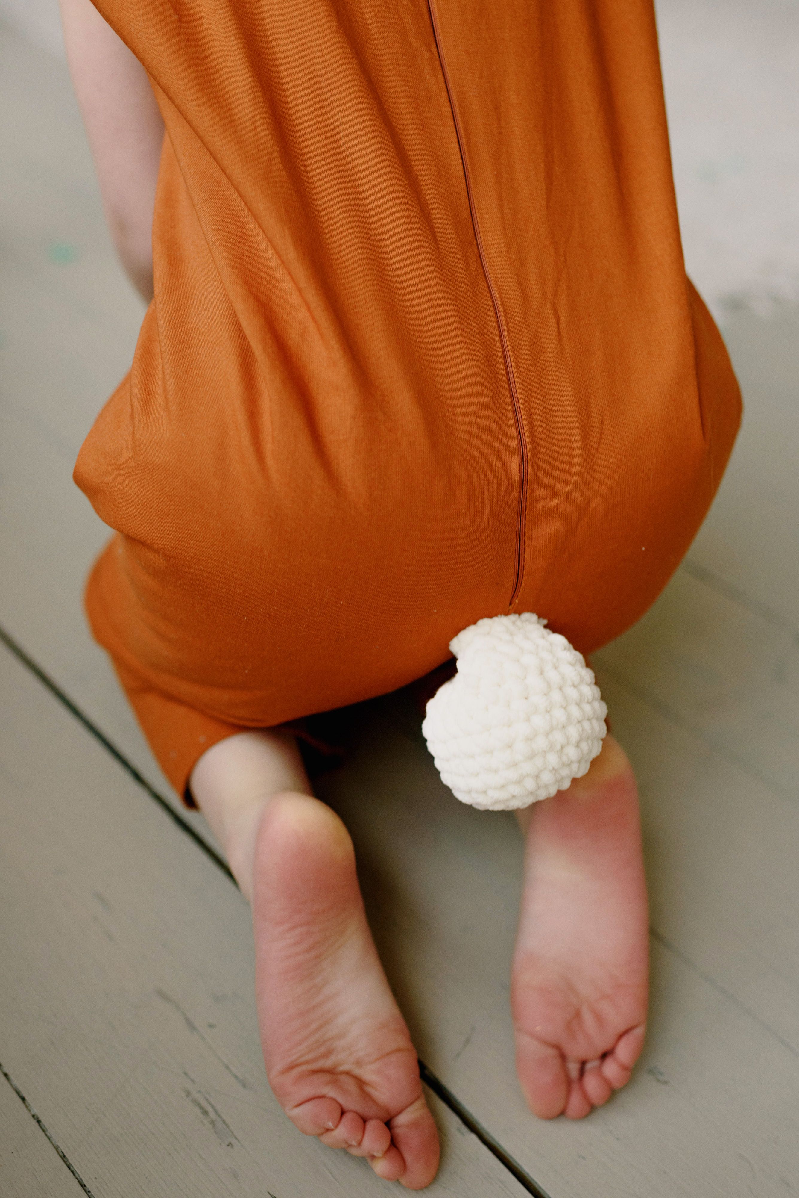 Close up of a Woman Wearing Black Bodysuit Kneeling on an Orange Floor