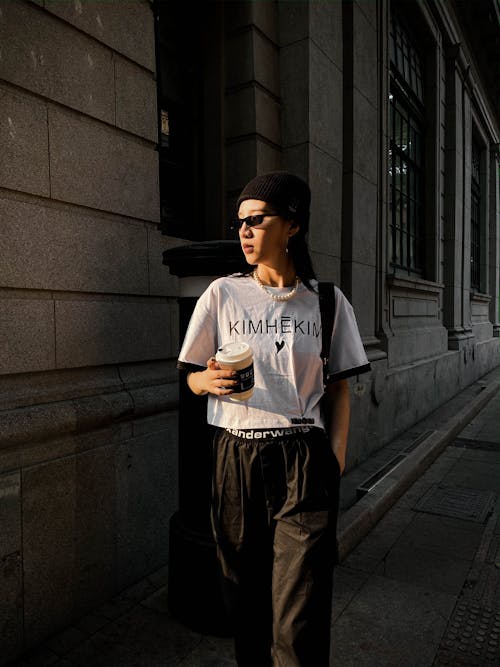 Free Man in White Crew Neck T-shirt and Black Pants Standing on Sidewalk Stock Photo
