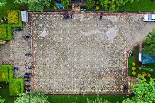 Top-down view of a parking lot surrounded by greenery in Jakarta, Indonesia.