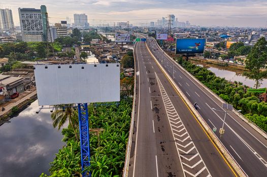 Aerial view of Jakarta's highway amid the bustling cityscape with visible high-rise buildings.