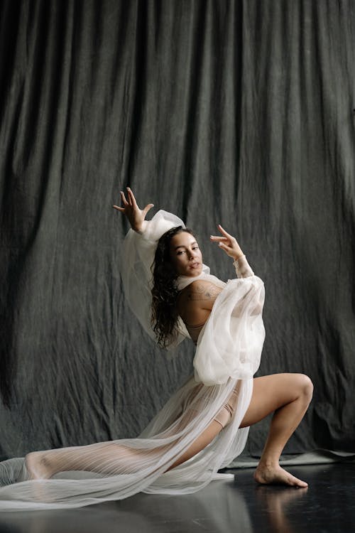 Woman Posing in White See Through Clothes on Gray Background