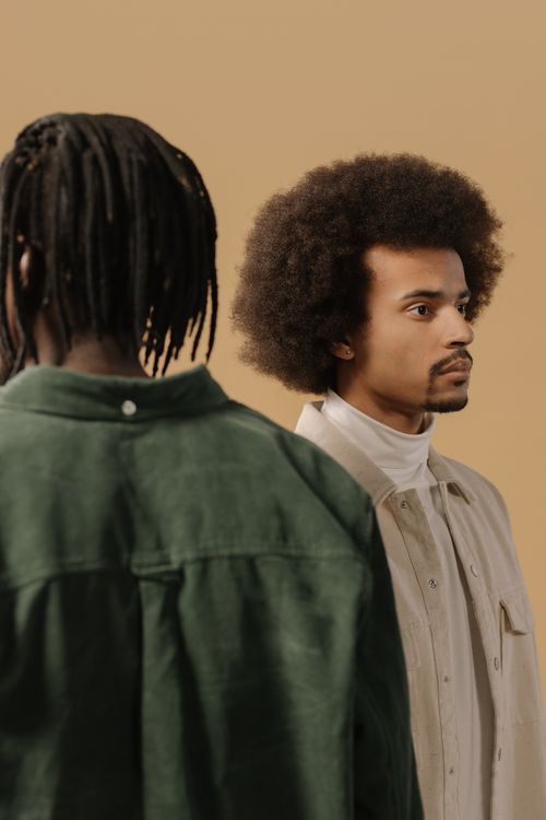 Free Fashionable portrait of two stylish men with afro hairstyles in a studio setting. Stock Photo