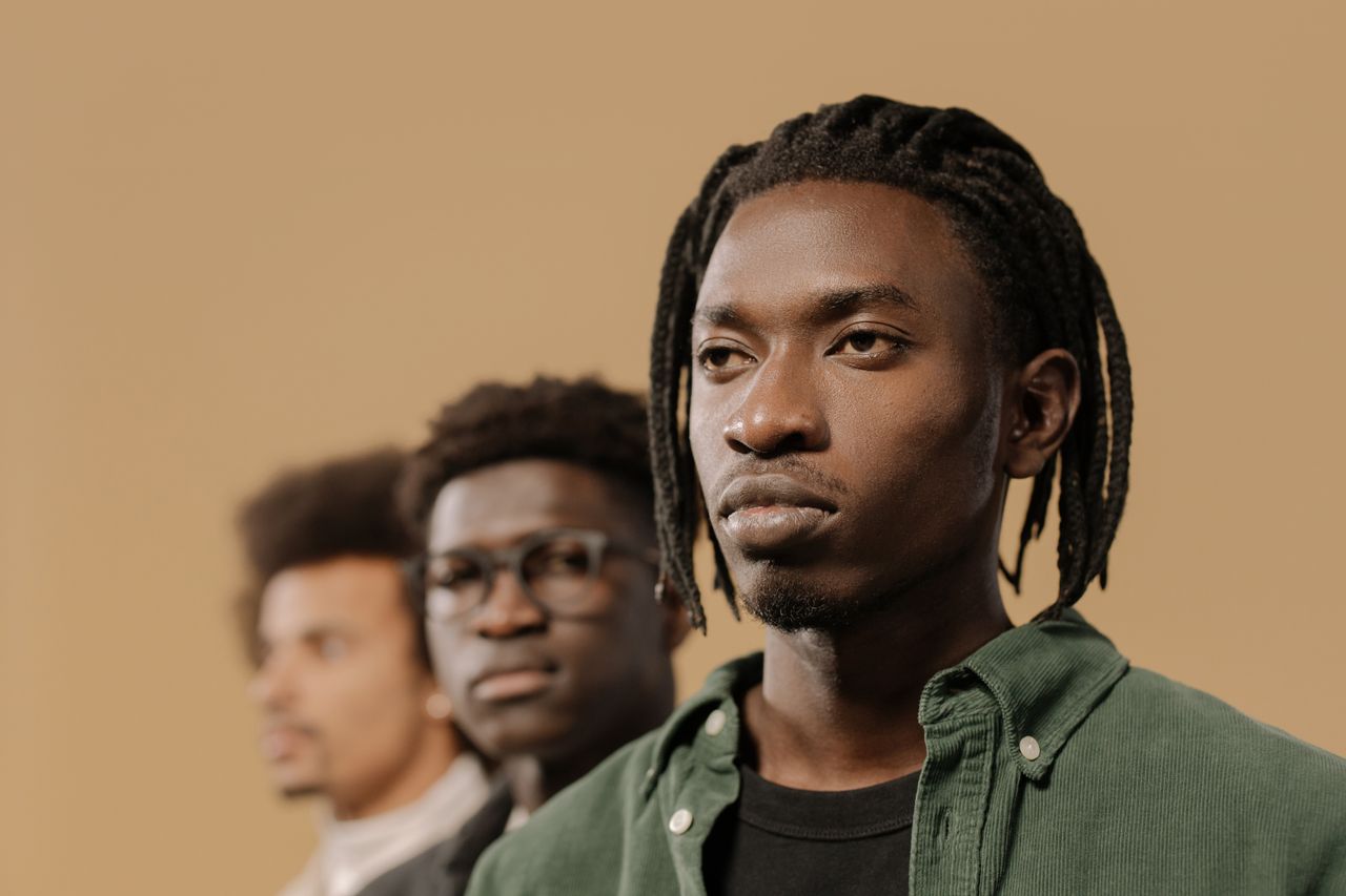 stylish portrait of three men with unique hairstyles in a studio setti