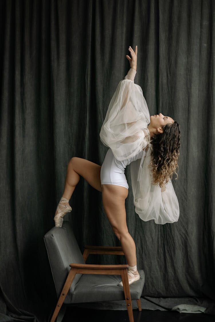 Woman Dancing On A Chair In White Tulle Sleeves And Bodice 